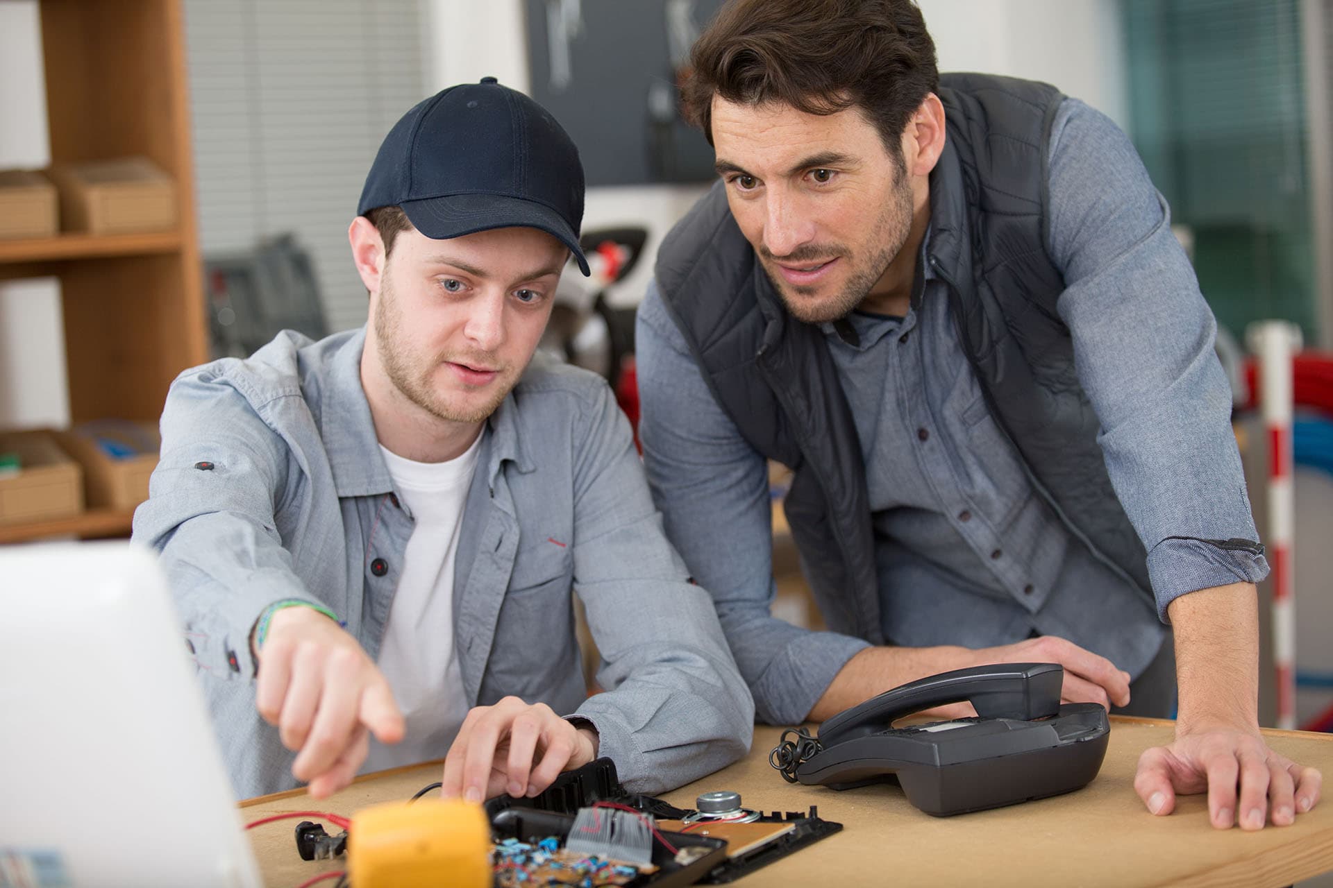Student technician with dismantled telephone